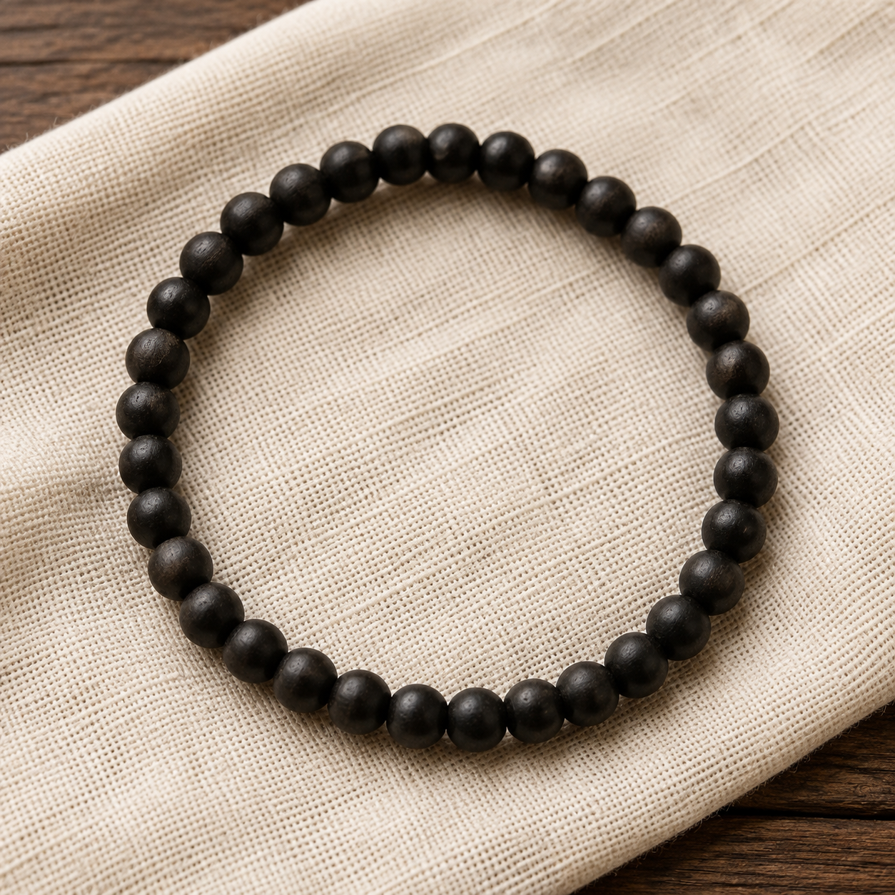Plain Bhakthination Karungali bracelet on ivory linen