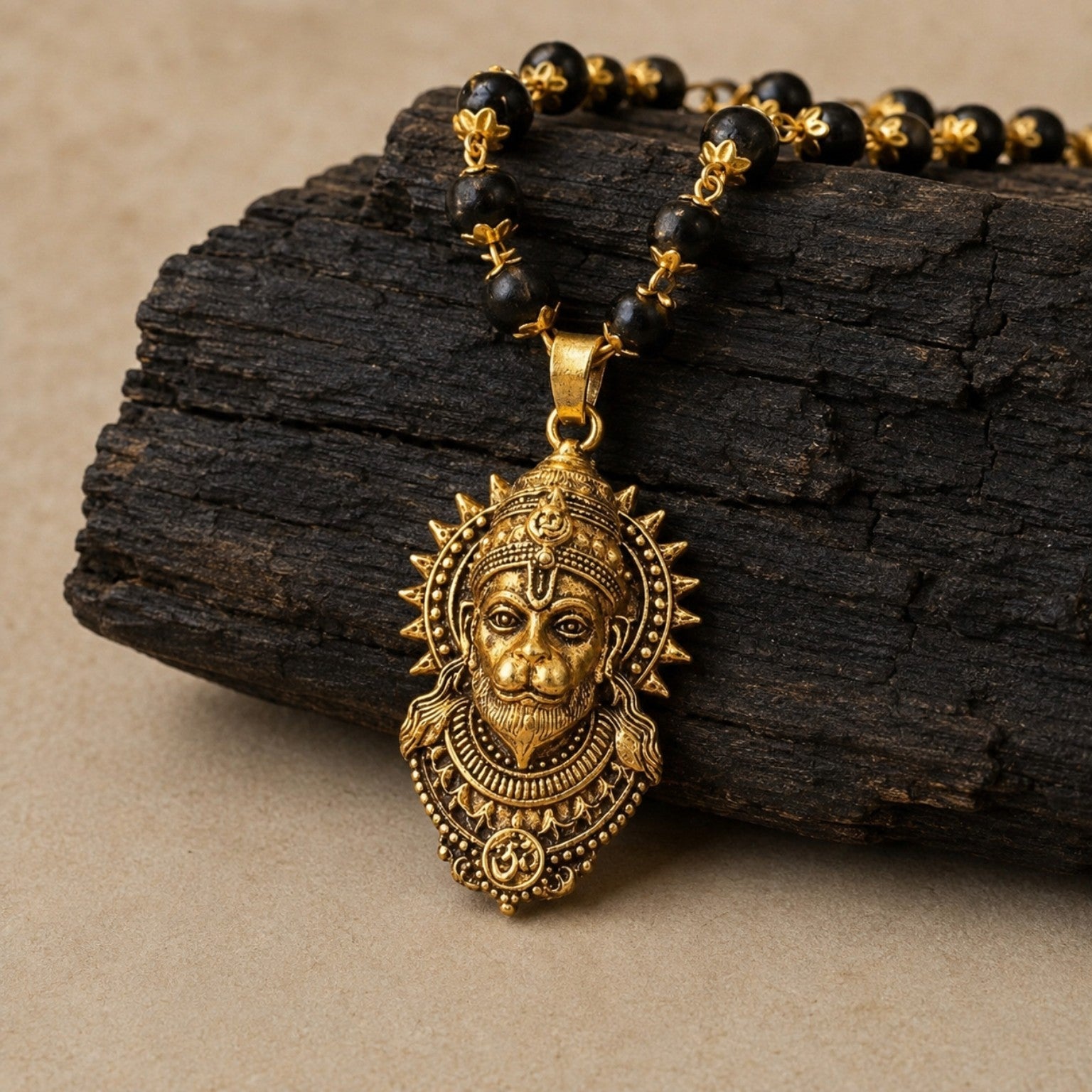 Gold Hanuman Karungali Mala on dark wood