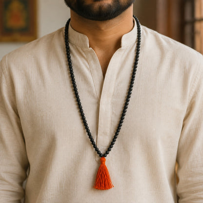 Classic Karungali Mala with orange tassel worn by a model